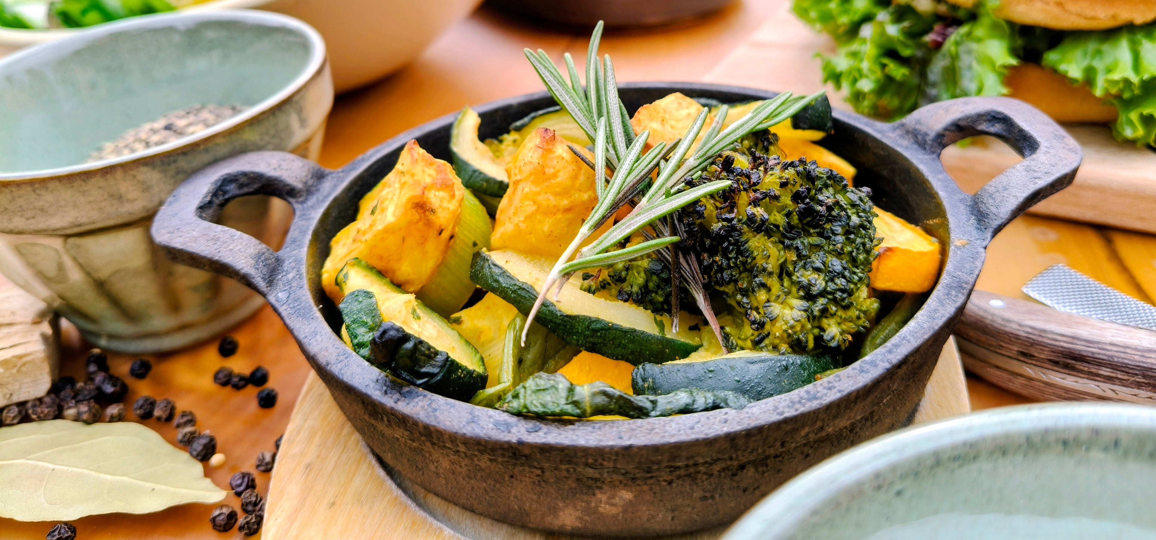 Groentegerecht met broccoli en courgette in een gietijzeren koekenpan op een houten oppervlak van that chef prive diner